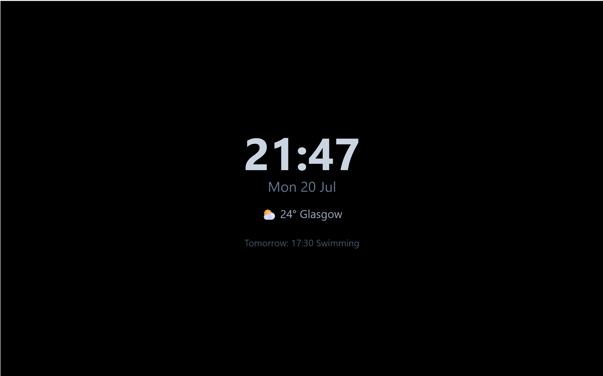 The wall display at night: a dimmed clock on a black screen with the date, the weather and tomorrow's first event.